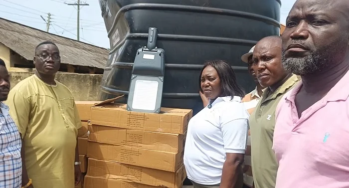 BRIDGE Inset Ms Sowah third from right handing over the streetlight polythank and one of the footbri