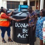 PWDs empowered Ms Nongo left presenting a Polytank to beneficiary and his family
