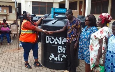 PWDs empowered Ms Nongo left presenting a Polytank to beneficiary and his family