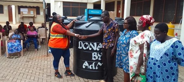 PWDs empowered Ms Nongo left presenting a Polytank to beneficiary and his family