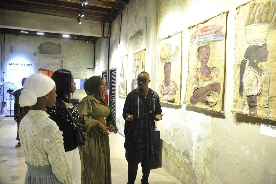 Artist turns street Mr Wayo right explaining the meaning of the exhibited works