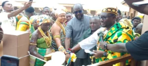 Keta Assembly hands over new KG block inset Togbi Kissi Avuabatsi right being assisted to cut the ta